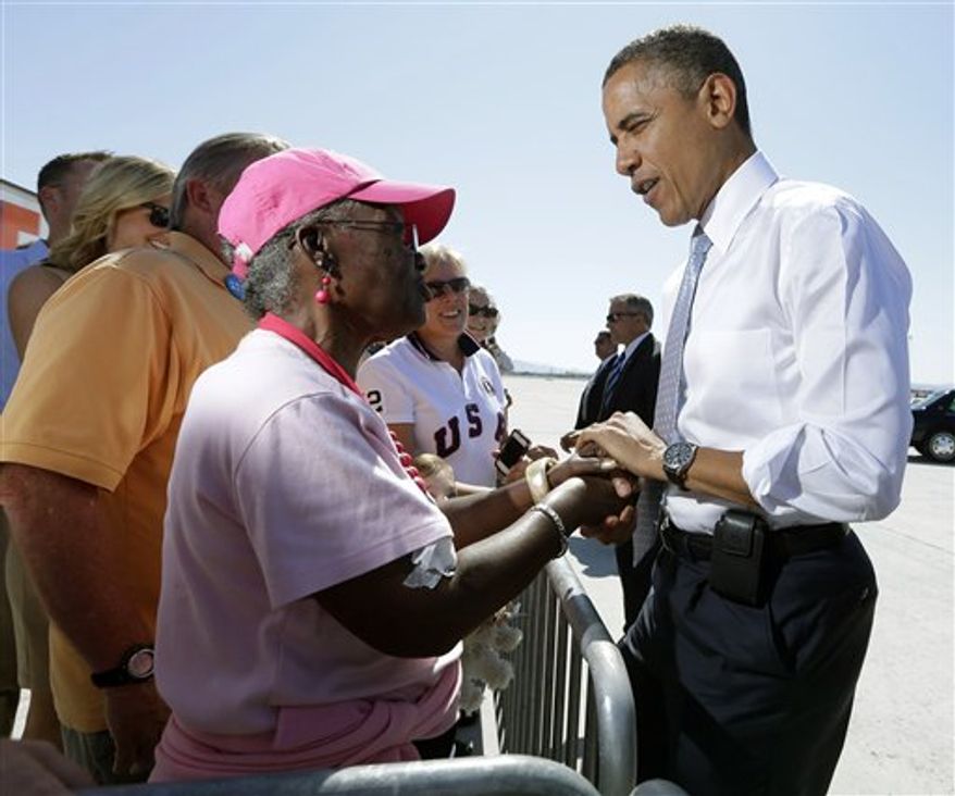 President Obama greets supporters on the tarmac upon his arrival at McCarran International airport, Sunday, Sept. 30, 2012 in Las Vegas. Obama traveled to Las Vegas for a campaign rally then will be staying in Henderson, Nev., to prepare for the first Presidential debate. (AP Photo/Pablo Martinez Monsivais)