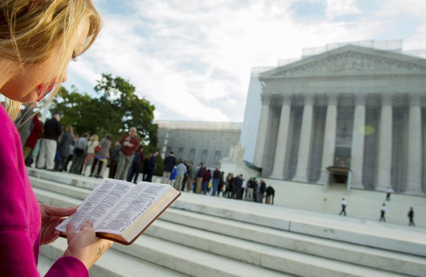 A woman holds a Bible while standing in silent prayer on the steps of the U.S. Supreme Court on Oct. 1, 2012, before the justices return to the bench for another term. (Rod Lamkey Jr./The Washington Times)