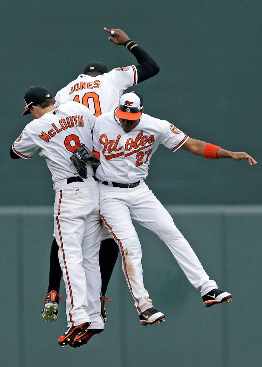 Orioles outfielders Nate McLouth, Adam Jones and Endy Chavez celebrate after a 6-3 win over Boston at Camden Yards on Sunday. Baltimore clinched at least a wild-card berth in the AL playoffs. (Associated Press)