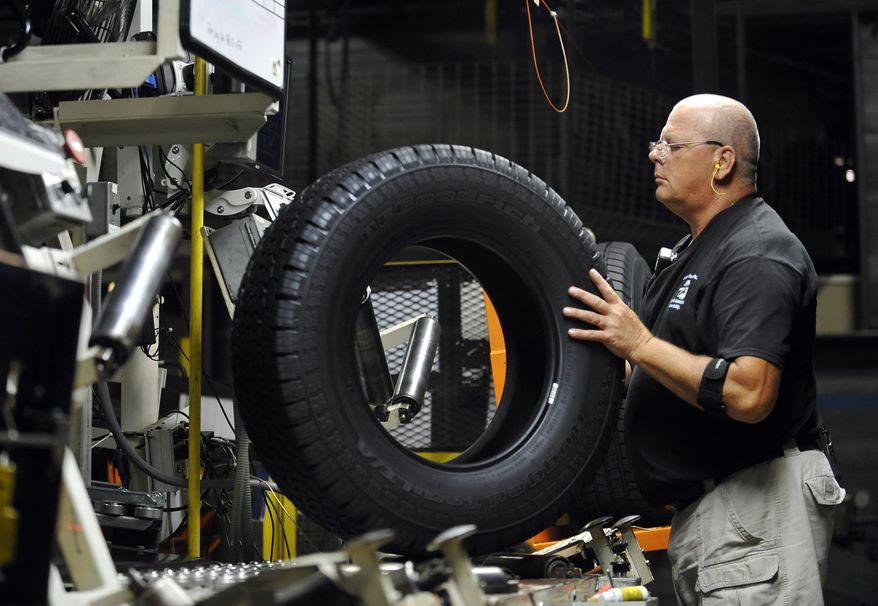 Inspector Buddy Rice checks for tire defects at a Michelin manufacturing plant in Greenville, S.C., on Tuesday, July 24, 2012. (AP Photo/Rainier Ehrhardt)