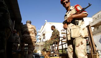 Libyan security forces stand guard as people turn in weapons in Benghazi, Libya, on Sept. 29, 2012. Hundreds responded to a call from the military to hand over their weapons — some driving in with armored personnel carriers, vehicles with mounted anti-aircraft guns and hundreds of rocket launchers. (Associated Press)