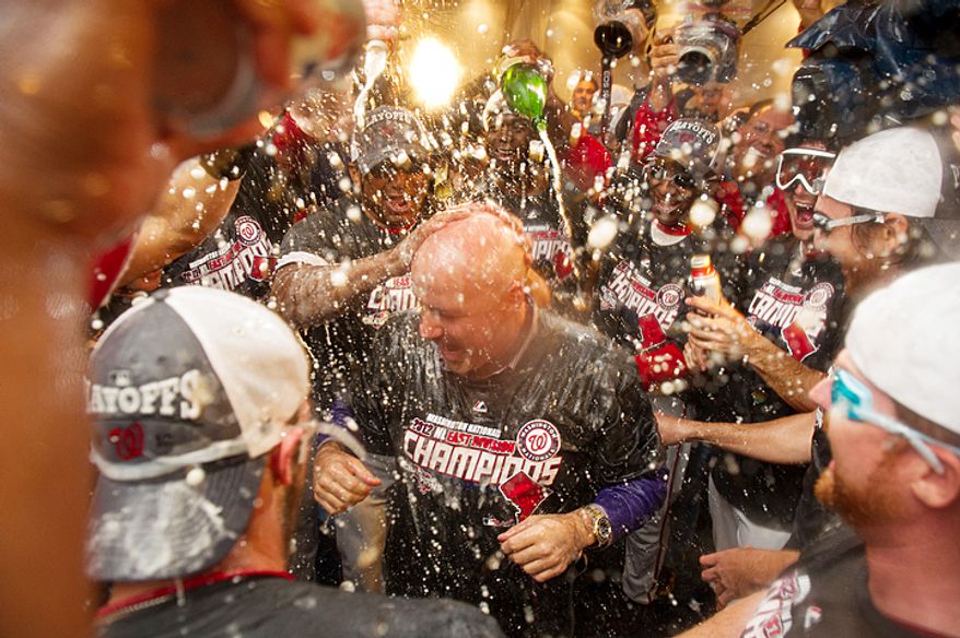 Mike Rizzo, center, celebrates making the playoffs with the team after the Washington Nationals in their locker room at Nationals Park, Washington, D.C., Monday, October 1, 2012. (Andrew Harnik/The Washington Times)