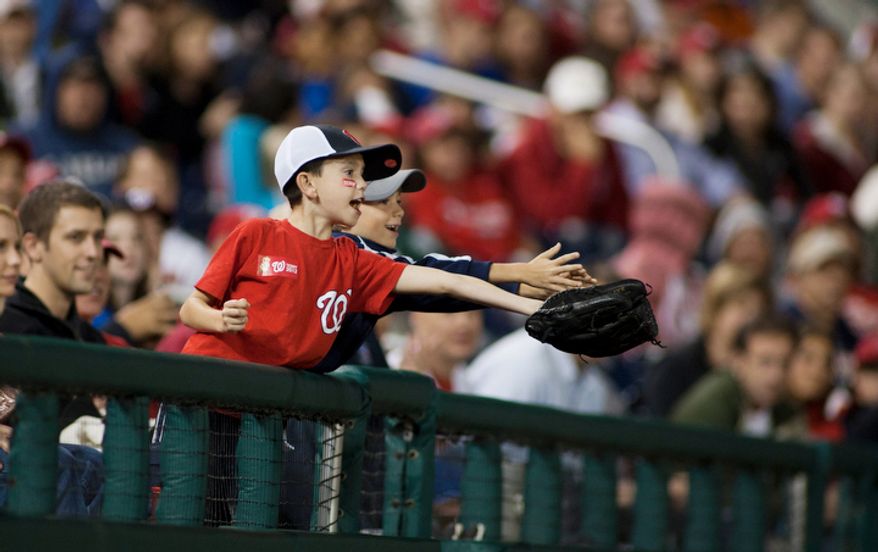 Washington National kids reach for a foul ball in the second inning. (Craig Bisacre/The Washington Times)