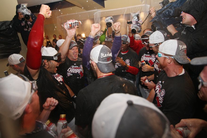 The Washington Nationals celebrate after clinching division champ with a lose to the Philadelphia Phillies but win by Pittsburg Pirates over the Atlanta Braves at Nationals Ballpark. (Craig Bisacre/The Washington Times)