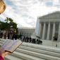 ** FILE ** A woman holds a Bible while standing in silent prayer on the steps of the Supreme Court on Oct. 1, 2012, before the justices return to the bench for another term. (Rod Lamkey Jr./The Washington Times)