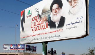 ** FILE ** In this photo Sept. 16, 2012, photo, a poster depicting Iran’s supreme leader Ayatollah Khamenei, right, and Ayatollah Mohammed Sadiq al-Sadr, late father of the radical anti-U.S. cleric Muqtada al-Sadr in Baghdad, Iraq. After years of growing influence, a new sign of Iranís presence in Iraq has hit the streets. Thousands of signs, that is, depicting Iranís supreme leader gently smiling to a population once mobilized against the Islamic Republic in eight years of war. (AP Photo/Karim Kadim)