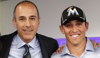 This image released by NBC shows host Matt Lauer, left, posing with Adam Greenberg after an appearance on the &quot;Today&quot; show, Thursday, Sept. 27, 2012 in New York. The Marlins said Thursday that they have signed Greenberg to a one-day contract, effective Oct. 2, and will play him that day against the New York Mets. Greenberg made his big-league debut for the Chicago Cubs on July 9, 2005 against the Marlins, getting one plate appearance but no official at-bat after a 92 mph fastball that struck him in the head. Greenberg was the subject of a campaign called &quot;One At Bat,&quot; which lobbied teams to give him a second chance.  The Marlins publicly extended the invitation to Greenberg on NBC&#x27;s &quot;Today&quot; show Thursday morning.  (AP Photo/NBC NewsWire, Peter Kramer)