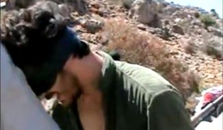 In an image taken from undated video posted to YouTube, American freelance journalist Austin Tice, who was reporting for American news organizations in Syria until his disappearance in August, prays in Arabic and English while blindfolded in the presence of gunmen. The Associated Press could not independently confirm the origin or the content of the clip, but the Tice family released a statement to several media outlets confirming it was their son in the video. (AP Photo)