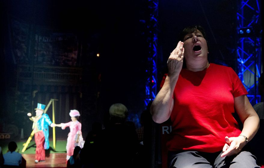 Faith Hurley, who works with the Fairfax County Public Schools system, uses cued speech, a method of visually representing sounds in English, so that hearing-impaired students can understand what is happening in the ring during the Circus of the Senses performance. More than 1,200 children and adults were on hand Wednesday. (Barbara L. Salisbury/The Washington Times)