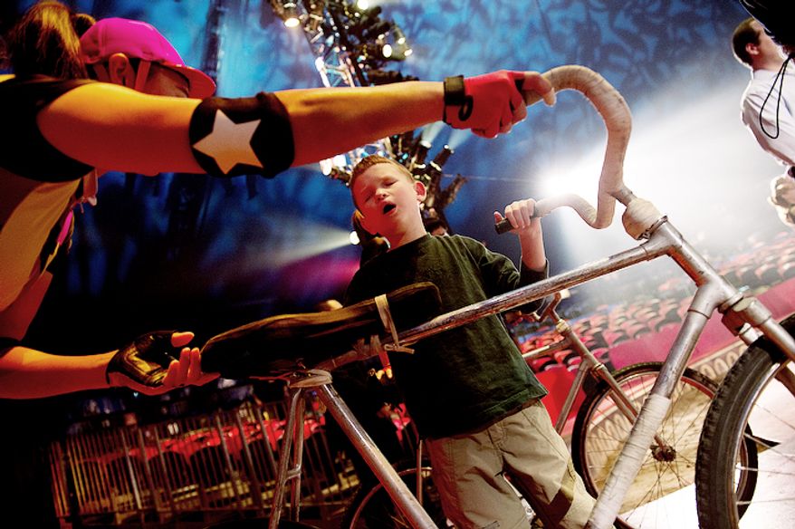 Max Smith-Levin, 7, of Warrenton, Va., feels one of the bicycles from the Dalian Acrobatic Troupe during a special "touch session" following the Big Apple Circus's "Circus of the Senses" performance on Wednesday, Oct. 3, 2012 in Sterling, Va. Max is one of the visually impaired audience members who was invited into the ring after the show to get an up-close look at some of the props and costumes. (Barbara L. Salisbury/The Washington Times)