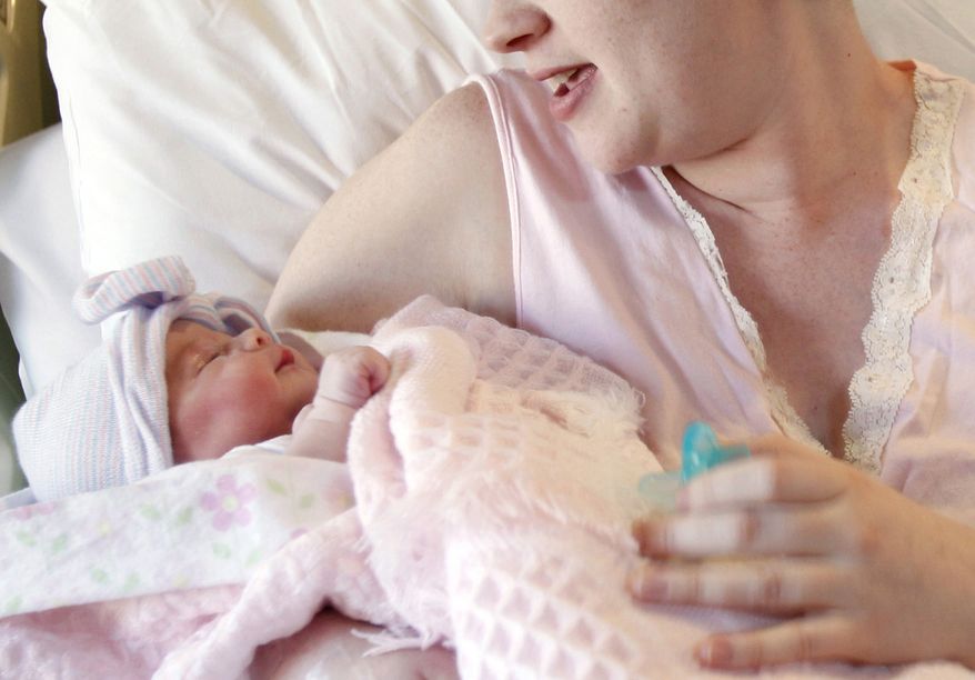 A mother holds her newborn baby at Christus Spohn Hospital South in Corpus Christi, Texas, on Friday, Nov. 11, 2011. (AP Photo/Corpus Christi Caller-Times, Michael Zamora)