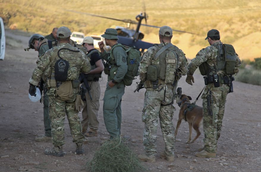 **FILE** Law enforcement officers gather Oct. 2, 2012, at a command post in the desert near Naco, Ariz., after a Border Patrol agent was shot to death near the U.S.-Mexico line. The agent, Nicholas Ivie, 30, and a colleague were on patrol about 100 miles from Tucson, when shooting broke out shortly before 2 a.m., the Border Patrol said. (Associated Press/U.S. Customs and Border Protection)