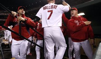 St. Louis Cardinals&#39; Matt Holliday is congratulated by manager Mike Matheny, left, and hitting coach Mark McGwire, right, after driving in a run with a sacrifice fly during the first inning of a baseball game against the Cincinnati Reds on Tuesday, Oct. 2, 2012, in St. Louis. (AP Photo/St. Louis Post-Dispatch, Chris Lee)
