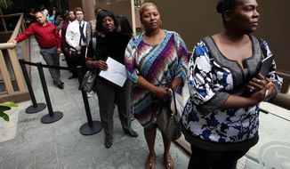 **FILE** Sheila Bird (right) waits in line for employment interviews at a Aug. 17, 2012, job fair at City Target in Los Angeles. (Associated Press)