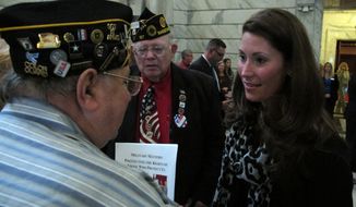 Kentucky Secretary of State Alison Lundergan Grimes, right, speaks with veterans on Wednesday, Sept. 19, 2012, at the Capitol in Frankfort, Ky. Grimes is pressing for legislation to make it easier for deployed troops to vote in Kentucky elections. (AP Photo/Roger Alford)