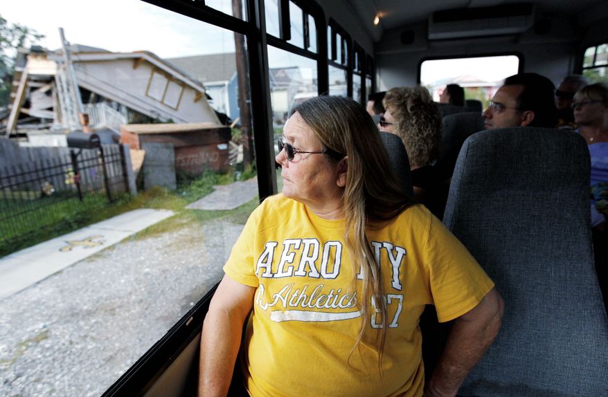 Kathy Stewart, of Enfield, Ill., looks at a wrecked house as her tour bus passes through the 9th Ward part of New Orleans. Residents and city officials are pushing back against tour companies that take out-of-towners into the Lower 9th Ward, the neighborhood devastated by Hurricane Katrina flooding. (Associated Press)