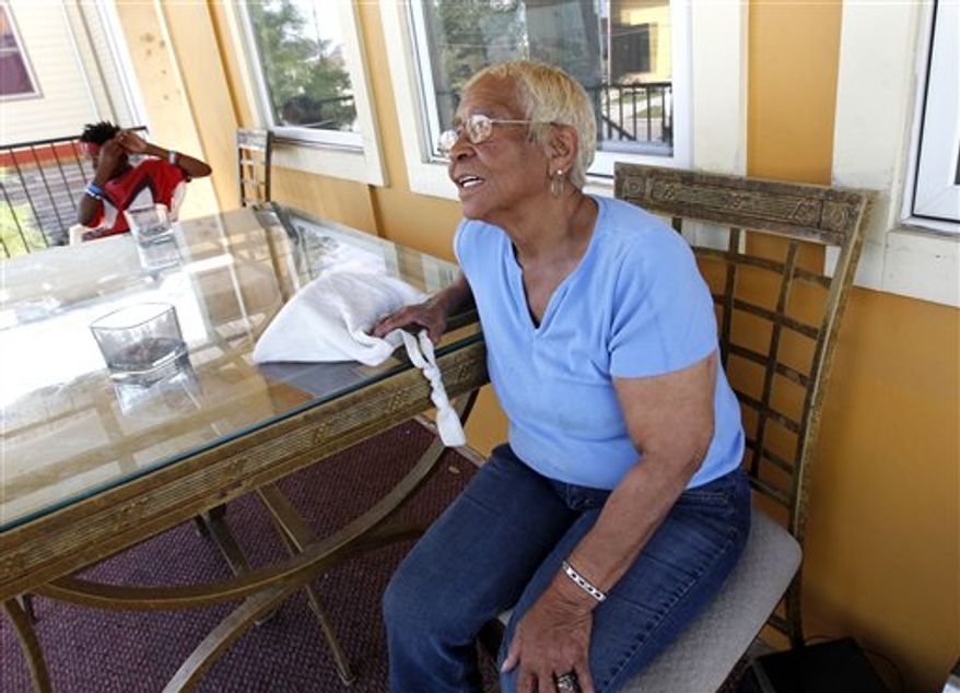 Lower 9th Ward resident Gloria Guy talks on her front porch in New Orleans, Tuesday, Oct. 2, 2012. Residents and the City of New Orleans may be pushing back against tour companies ushering out-of-towners into to the Lower 9th Ward, the neighborhood made famous when floodwalls and levees failed in 2005, pushing homes off their foundations and stranding residents on rooftops. (AP Photo/Gerald Herbert)
