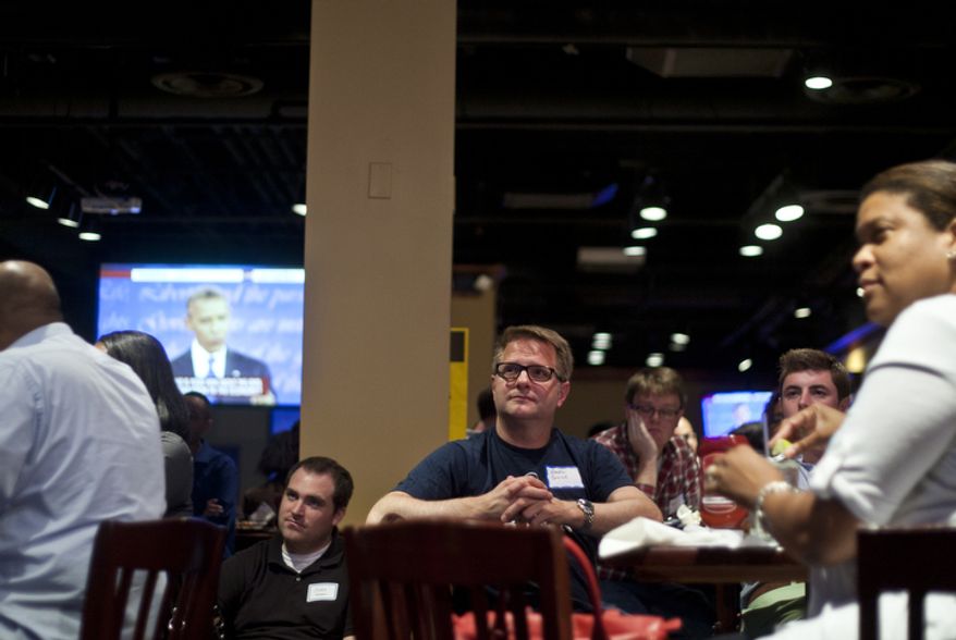 Greg Guice, of Arlington, Va., watches the first presidential debate between President Obama and Republican nominee Mitt Romney during a watch party put on by the Arlington Young Democrats and the Arlington County Democratic Committee at Bailey's Pub in Ballston Common Mall, Ballston, Va., Wednesday, Oct. 3, 2012. (Craig Bisacre/The Washington Times)
