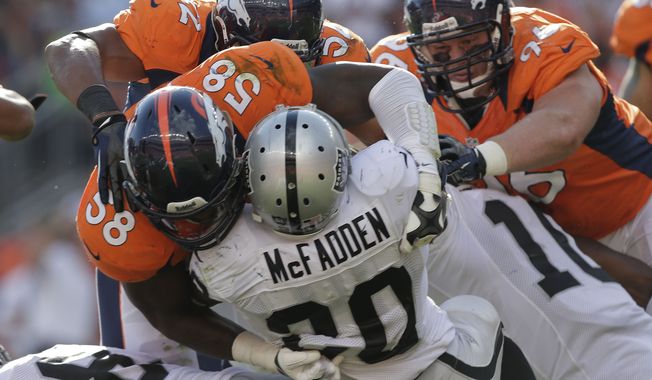 Oakland Raiders running back Darren McFadden (20) is stopped by Denver Broncos outside linebacker Von Miller (58), defensive end Mitch Unrein (96) and outside linebacker Wesley Woodyard (52) during the third quarter of an NFL football game, Sunday, Sept. 30, 2012, in Denver. (AP Photo/Joe Mahoney)