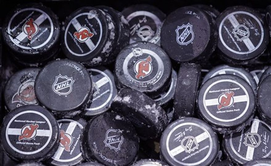 ** FILE ** In this May 15, 2012, file photo, ice covered hockey pucks are shown at the New Jersey Devils practice rink in Newark, N.J. The NHL said Thursday, Oct. 4, 2012, that it has canceled the hockey season through Oct. 24, a total of 82 games, because of the ongoing lockout. The NHL and the players' union are unable to decide how to divide $3 billion in hockey-related revenues. There have been negotiations in recent days, but the sides have not gotten any closer to an agreement on core economic issues. (AP Photo/Julio Cortez, File)
