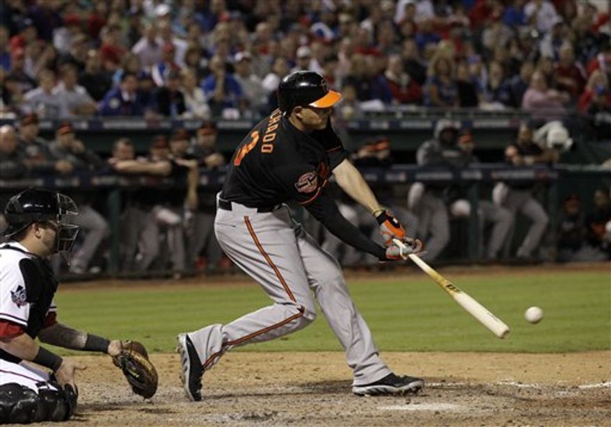 Texas Rangers catcher Mike Napoli (25) watches as Baltimore Orioles' Manny Machado (13) connects for a run scoring single off of Rangers closer Joe Nathan in the ninth inning American League wild-card playoff baseball game Friday, Oct. 5, 2012, in Arlington, Texas. The shot scored Lew Ford. (AP Photo/Tony Gutierrez)