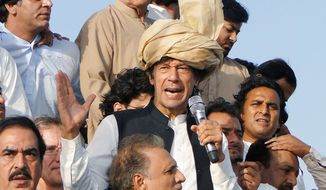 Imran Khan (center), Pakistan’s ex-cricket star-turned-politician, talks to backers during a march in Tank, Pakistan, on Sunday. The Pakistani military blocked a convoy carrying thousands of Pakistanis and a contingent of U.S. anti-war activists. (Associated Press)