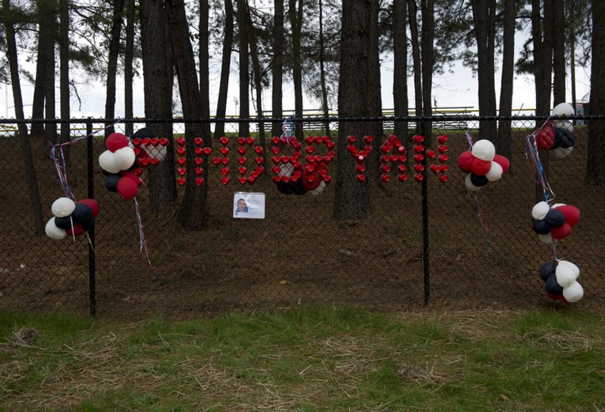 The message "Find Bryan" is written in red plastic cups on a fence outside W.T. Woodson High School along with a flier about missing Woodson senior Bryan Glenn. A body was found off the trail in Thaiss Memorial Park in Fairfax, Va. on Monday, Oct. 8, 2012. Fairfax County Police have not yet determined if it is Glenn, who was last seen Oct. 1 when he dropped his brother off at school and whose car was found in the park's parking lot on Tuesday. A search party set out near 10 a.m. this morning and a small group later found the body. (Barbara L. Salisbury/The Washington Times)