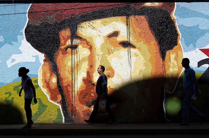 People walk past a mural depicting Venezuelan President Hugo Chavez in Caracas, Venezuela, on Monday, Oct. 8, 2012. Mr. Chavez won re-election and a new endorsement of his socialist project Sunday, surviving his closest race yet after a bitter campaign against opposition candidate Henrique Capriles. (AP Photo/Rodrigo Abd)