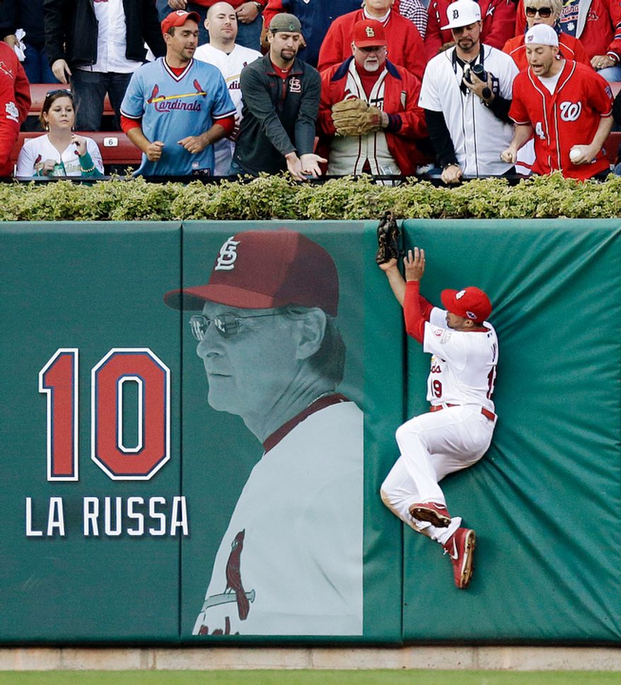 St. Louis Cardinals center fielder Jon Jay leaps at the wall to catch a fly ball off the bat of Washington Nationals' Danny Espinosa during the sixth inning of Game 2. (AP Photo/St. Louis Post-Dispatch, Chris Lee)