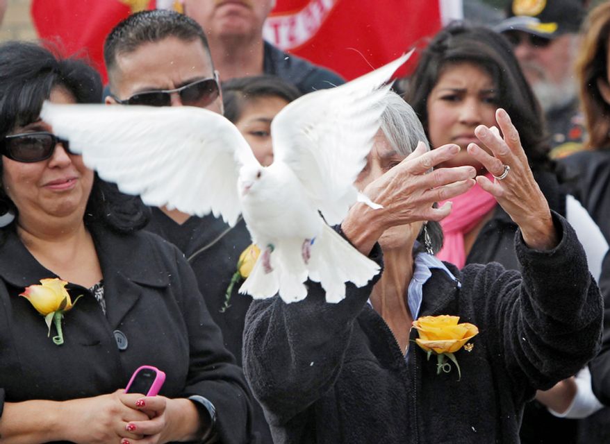 Delouise Guerra the sister of Marine PFC James Jacques releases one of 21 doves after his funeral at Fort Logan National Cemetery in Denver on Tuesday, Oct. 9, 2012. The Jacques funeral was held 37 years after he was killed during the rescue of the crew of an American cargo ship seized by Cambodia in May of 1975. His remains were identified in August 2012. (AP Photo/Ed Andrieski)