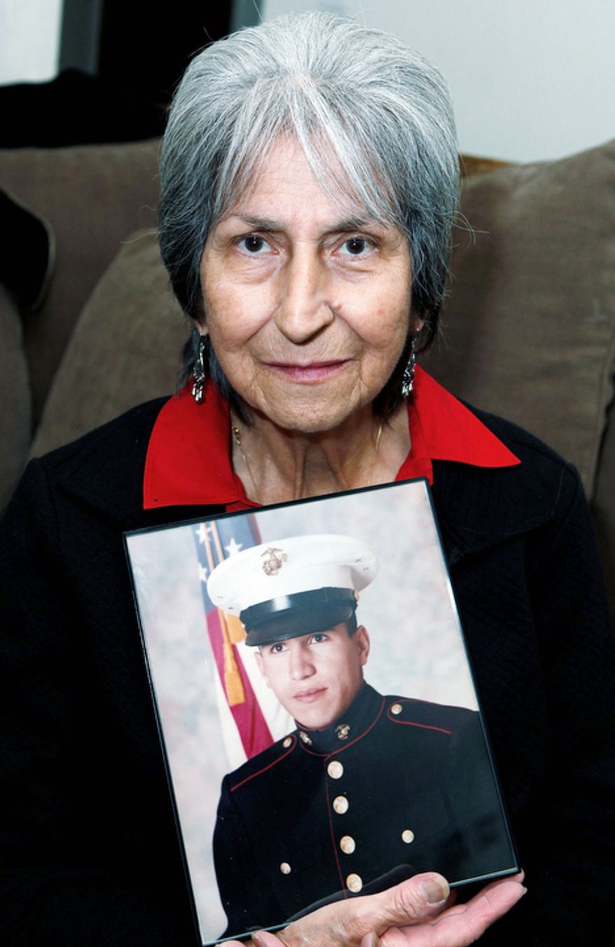 In this Oct. 5, 2012, photo Delouise Guerra poses for a photo in Denver with a 1975 photo of her younger brother,18-year-old Marine PFC James Jacques who was killed in a helicopter crash near Cambodia in 1975. Jacques remains were identified in August of this year. He will be buried with full military honors at Fort Logan National Cemetery in Denver on Tuesday, Oct. 9, 2012, on what would have been his 56th birthday. (AP Photo/Ed Andrieski)