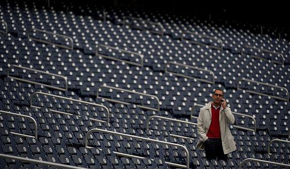 ** FILE ** Saint Louis Cardinals vice president and general manager John Mozeliak talks on the phone in the stands while his team takes to the field to practice at Nationals Park on Tuesday, Oct. 9, 2012. (Barbara L. Salisbury/The Washington Times)