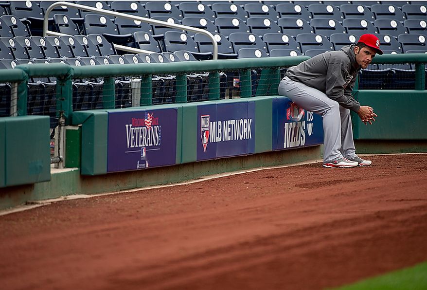 Saint Louis Cardinals player Jaime Garcia, who pitched for two innings in Monday's game before acknowleding a broken arm, watches on the sidelines while his team work outs at Nationals Park on Tuesday, Oct. 9, 2012. On Wednesday, they play the St. Louis Cardinals at home. (Barbara L. Salisbury/The Washington Times)