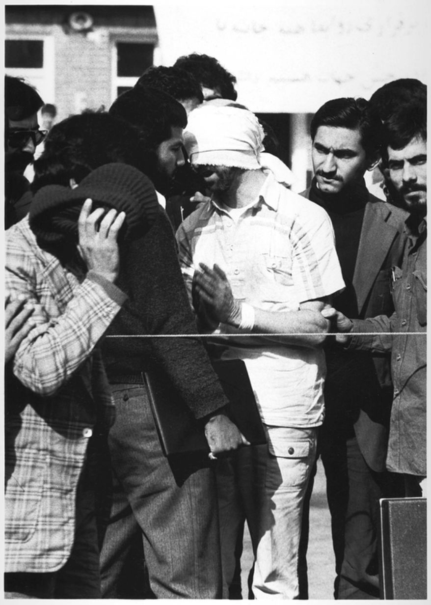 One of 60 U.S. hostages, blindfolded and with his hands bound, is being displayed to the crowd outside the U.S. Embassy in Tehran by Iranian hostage takers. (AP Photo)