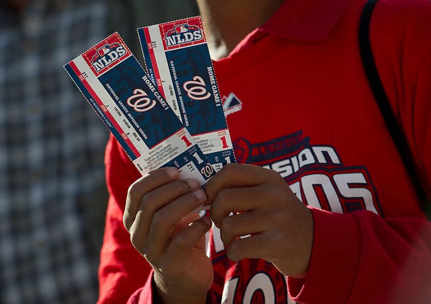 A young fan holds up his tickets for the Nationals' first home playoff game at Nationals Park on Wednesday, Oct. 10, 2012. (Barbara L. Salisbury/The Washington Times)