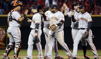 San Francisco Giants players celebrate after defeating the Cincinnati Reds 8-3 in Game 4 of the National League division baseball series, Wednesday, Oct. 10, 2012, in Cincinnati. (AP Photo/Michael Keating)