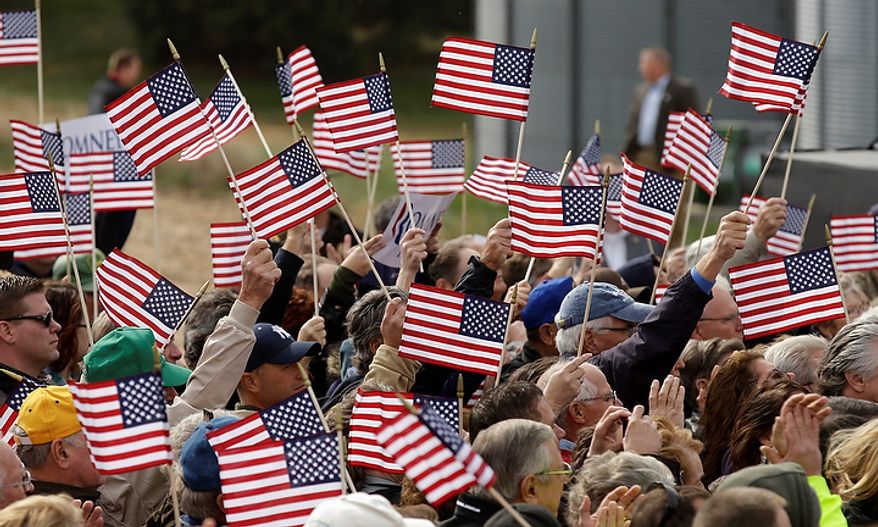 Supporters wave flags during Republican Mitt Romney's campaign stop on Oct. 9, 2012, in Van Meter, Iowa. (AP Photo/Charlie Neibergall)