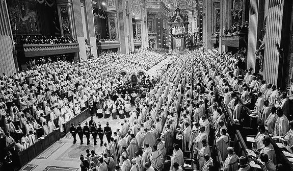 Roman Catholic prelates stand as Pope Paul VI, on portable throne, is escorted through the main nave of St. Peter&#x27;s Basilica in Vatican City to address the last meeting of the Ecumenical Council&#x27;s second session,  Dec. 4, 1963.  The pontiff recessed the council for nine months after urging prelates to share with him in governing the Church. (AP Photo)