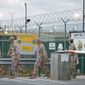 U.S. troops in May 2009 walk near the military detention facility at Guantanamo Bay, Cuba. Congressional Republicans have expressed new suspicions that the Obama administration intends to move Guantanamo detainees to Thomson Correctional Center, a currently unused facility in Illinois. (Associated Press)
