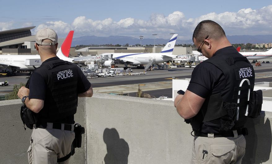 Department of Homeland Security police officers keep an eye on planes at Los Angeles International Airport. (AP Photo/Damian Dovarganes)