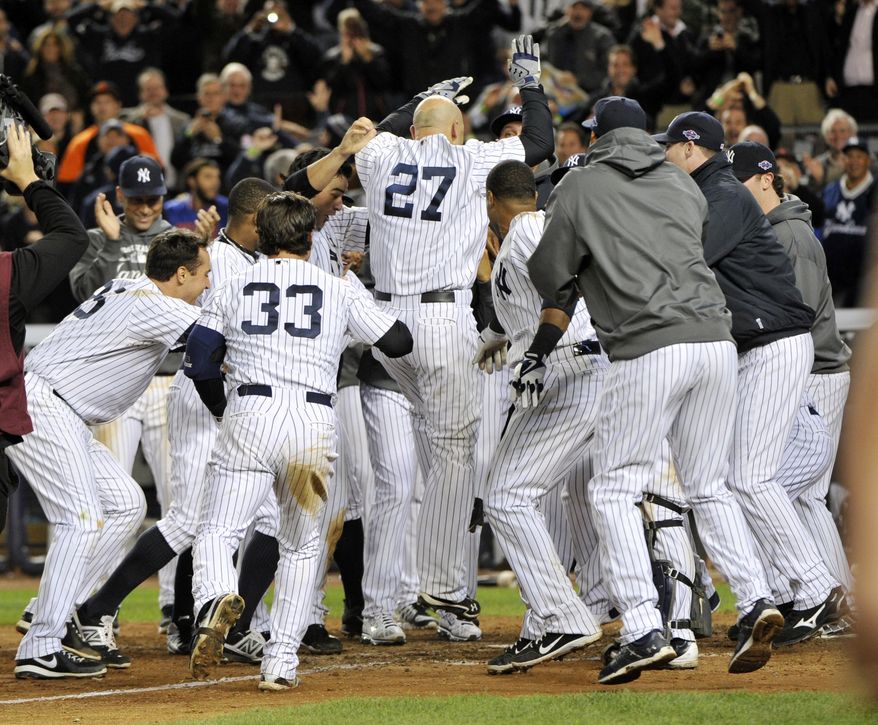 New York Yankees' Raul Ibanez (27) celebrates with teammates as he reaches home plate after hitting the game-winning home run during the 12th inning of Game 3 of the American League division baseball series against the Baltimore Orioles on Wednesday, Oct. 10, 2012, in New York. The Yankees won 3-2. (AP Photo/Bill Kostroun)