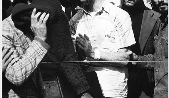 One of 60 U.S. hostages, blindfolded and with his hands bound, is being displayed to the crowd outside the U.S. Embassy in Tehran by Iranian hostage takers. At least 2 former U.S. hostages say they believe the bearded man, far right, is Iranian president-elect Mahmoud Ahmadinejad while several former hostage takers all said they did not think it was Ahmadinejad. A close aide to Ahmadenijad refused to look at the photos or comment on the issue in Teheran Thursday, June 30, 2005.  (AP Photo)