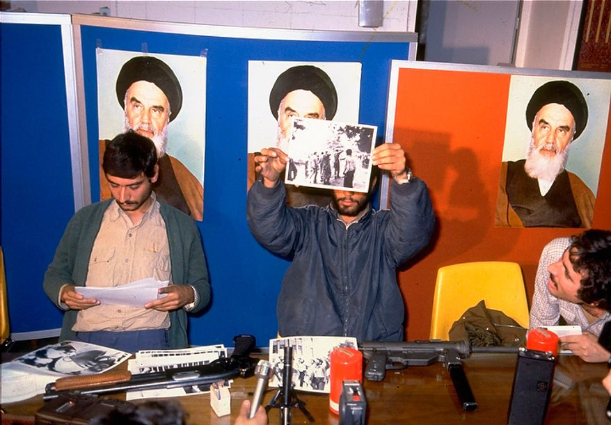 Iranian student spokesmen hold up photos of blindfolded American hostages, during a press conference in Tehran Monday November 5, 1979. The hostages are members of the staff of the United States Embassy in Tehran, which was stormed by students November 4. (AP Photo)