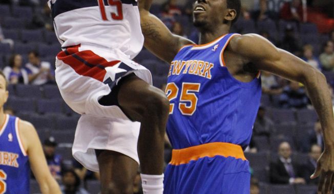 Washington Wizards guard Jordan Crawford (15) goes up for a shot over New York Knicks center Henry Sims (25) during the first quarter of an NBA preseason basketball game in Washington, Thursday, Oct. 11, 2012. The Knicks defeated the Wizards 108-101. (AP Photo/Ann Heisenfelt)