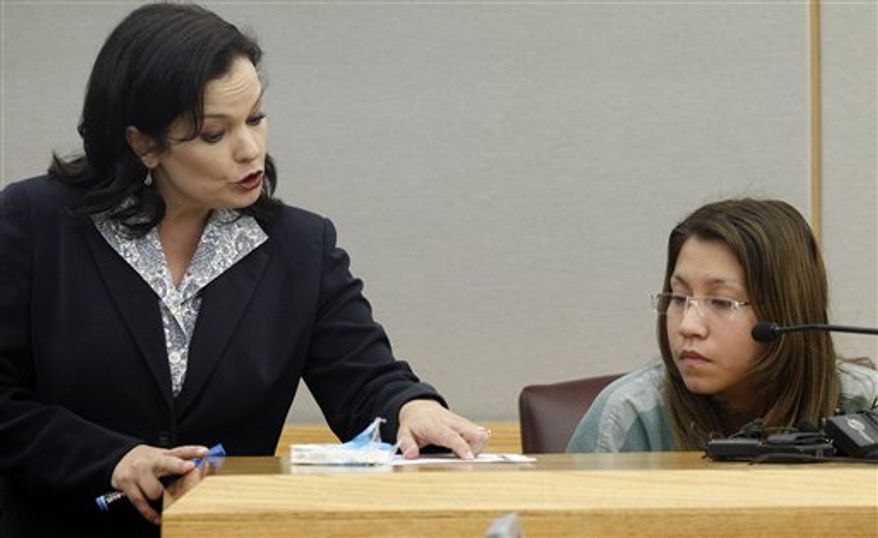 ** FILE ** In a Thursday, Oct. 11, 2012, file photo, prosecutor Eren Price, left, points to a piece of states evidence as she addresses Elizabeth Escalona, 23, during Escalona's sentencing proceedings in Dallas. Escalona was sentenced Friday, Oct. 12, 2012, to 99 years in prison for beating her toddler and gluing the child's hands to a wall. (AP Photo/Tony Gutierrez, File)