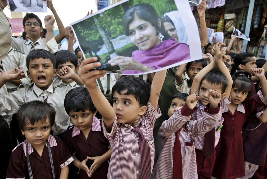 A Pakistani boy holds up a picture of 14-year-old schoolgirl Malala Yousufzai, who was shot on Tuesday, Oct. 9, 2012, by the Taliban for speaking out in support of education for women. The schoolboy and other children are attending a protest in Karachi, Pakistan, on Saturday, Oct. 13, 2012, to condemn the attack. (AP Photo/Fareed Khan)