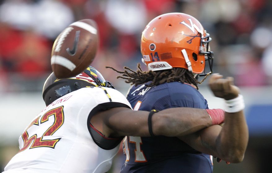 Maryland linebacker Darin Drakeford (52) forces a fumble from Virginia quarterback Phillip Sims (14) during the second half of an NCAA college football game at Scott Stadium in Charlottesville, Va., on Saturday, Oct. 13, 2012. Maryland won the game 27-20. (AP Photo/Steve Helber)