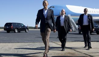 President Obama walks to greet people on the apron as he arrives at Newport News/Williamsburg International Airport aboard Air Force One on Saturday, Oct. 13, 2012, in Williamsburg, Va. (AP Photo/Carolyn Kaster)