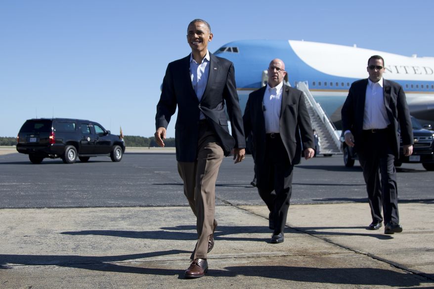 President Obama walks to greet people on the apron as he arrives at Newport News/Williamsburg International Airport aboard Air Force One on Saturday, Oct. 13, 2012, in Williamsburg, Va. (AP Photo/Carolyn Kaster)