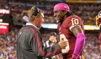 Washington Redskins quarterback Robert Griffin III (10) laughs with Washington Redskins head coach Mike Shanahan on the sideline after running a 76 yards for a touchdown to put the Washington Redskins up 38-26 in the fourth quarter. (Craig Bisacre/ The Washington Times)